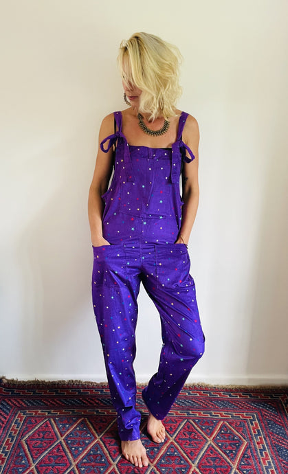 Buy now online from Emma's Emporium! Emma's Emporium Star Print Dungarees. Emma's Emporium limited edition star dungarees are now available to buy on our website! Super fun and comfortable dungarees, featuring tie straps, large front pockets and coconut buttons. Made from soft and fine star print needle cord cotton available in Purple with rainbow stars or Navy with gold stars. Shop Emma's Emporium for ethical fair trade slow fashion, women's and unisex hippie boho festival clothing and gifts.